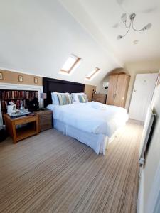 兰迪德诺Cleave Court Guest House的卧室配有一张白色大床和一张书桌