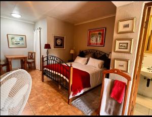 SandtonOakTree Guest House的卧室配有一张床和一张桌子及椅子