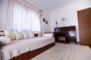 里托楚伦Rodon Apartment with Great View, Sauna and Jacuzzi的客厅配有床和钢琴