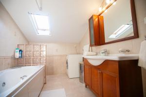 里托楚伦Rodon Apartment with Great View, Sauna and Jacuzzi的一间带水槽、浴缸和镜子的浴室