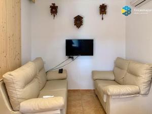 柳奇马约尔Cas rellotger country house的客厅配有2张白色沙发和1台平面电视