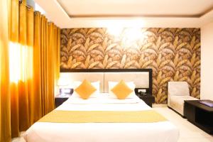新德里Hotel Aashiyana New Delhi的酒店客房配有一张带黄色枕头的床