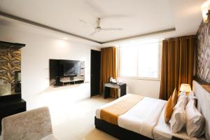 新德里Hotel Aashiyana New Delhi的酒店客房,配有床和电视