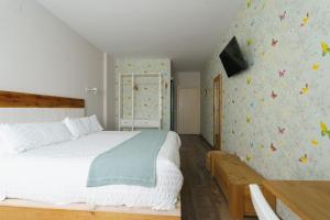 阿尔巴拉辛Hotel Casa Cauma的一间卧室配有床和蝴蝶墙