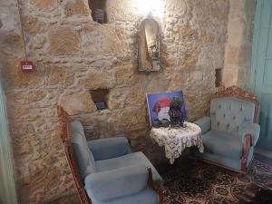 北尼科西亚Hotel Valide Hanim Konak的石墙,带两把椅子和桌子