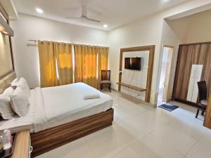 阿姆利则The Raj Darbar A Unit of Arora Hospitality的一间卧室配有一张床和一台电视
