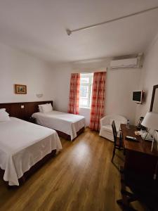 英雄港贝拉玛酒店的酒店客房配有两张床和一张书桌
