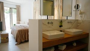 阿凯松Diana Palace Hotel Zakynthos的一间带两个白色水槽和一张床的浴室