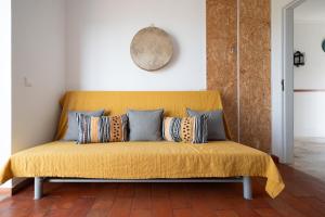 埃里塞拉Casa da Ribeira Quarto Turquesa的客房内的黄色沙发上配有枕头