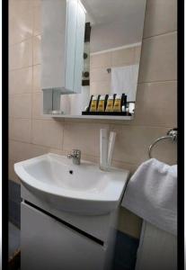 普拉蒂Odyssey's Feats的浴室设有白色水槽和镜子