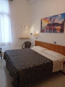 威尼斯卡纳瓦酒店的卧室配有一张床,墙上挂有绘画作品