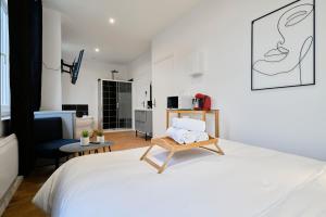 图尔昆NG SuiteHome - Lille I Tourcoing I Haute - Balnéo - Netflix的卧室配有一张白色大床和一把椅子