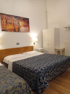 威尼斯卡纳瓦酒店的一间卧室设有两张床,墙上挂着一幅画