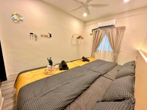 马六甲Kota Homestay-22pax with Karaoke,Arcade Game,Table Pool Walking 5min To Jonker的一间卧室配有一张带黄色毯子的大床