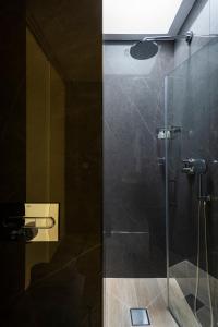 塞维利亚Casa de Triana Luxury Suites by Casa del Poeta的带淋浴的浴室和玻璃门