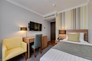 伦敦莫宁海德公园贝斯特韦斯特酒店的酒店客房配有一张床、一张桌子和一把椅子。