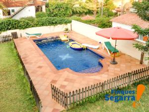 罗达德瓦拉Casa Emporda的一个带遮阳伞和椅子的游泳池以及一个泳池顾问
