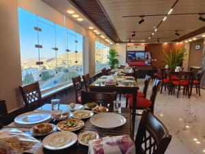 瓦迪穆萨Petra Crystal hotel的一间设有长桌的餐厅,提供餐盘