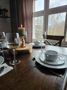 普鲁德尼克Dworek Szumilas的一张桌子,上面有盘子和玻璃杯,上面有蜡烛