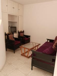 乌姆苏克Appartement R9的客厅配有3张沙发和1张咖啡桌