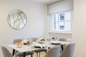 伦敦Urban Chic – Drury的一间带桌椅和镜子的用餐室