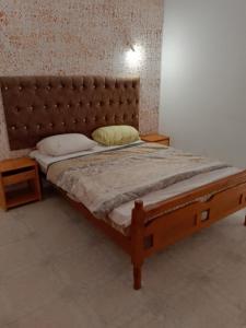 乌姆苏克Appartement R9的一间卧室配有一张带皮革床头板的大床