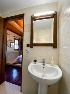 讷瑞达Σκίουρος的一间带水槽和镜子的浴室以及一张床