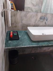 BelparāoJim Corbett Tiger Resort的一个带水槽的浴室和柜台上的一本书