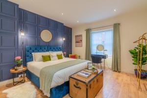 切尔滕纳姆Regency Basement Apartment的蓝色卧室,配有床和桌子