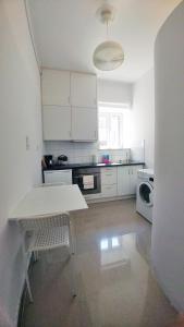 雅典KYMA Apartments - Athens Acropolis 2的白色的厨房配有桌子和微波炉