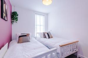 切斯特Large 7 bedroom town house in Chester City Centre的配有2张床的白色墙壁和窗户。
