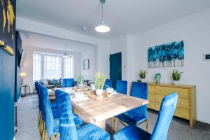 切斯特Large 7 bedroom town house in Chester City Centre的一间带桌子和蓝色椅子的用餐室