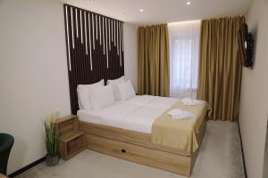 波热加Sax-Win的一间卧室配有一张带白色床单的大床