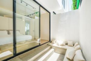 坎古Oasis Smart Villa 3 Canggu的一间设有床铺和玻璃墙的房间