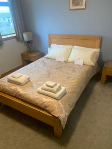奥克尼Polrudden的一间卧室配有一张床,上面有两条毛巾