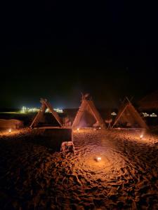 Dār as Salāmflamingo camp的一群晚上在海滩上的帐篷