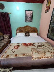 Barkotgaurav home stay的一间卧室配有一张大床和木制床头板