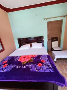 Barkotgaurav home stay的一间卧室配有一张床铺,床上铺有紫色毯子