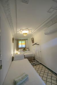 非斯Riad dar Yamna的一间设有两张床铺和窗户的房间