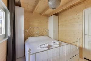 赞德沃特Moyo Kijani的卧室配有一张白色的木墙床