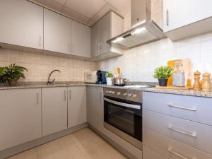 利乌玛Holiday Home Gaviota 9 by Interhome的厨房配有白色橱柜和炉灶烤箱。