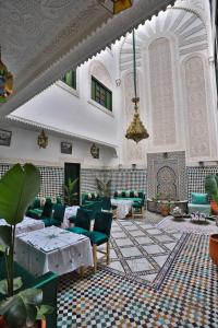 非斯Riad dar Yamna的大楼内带绿色桌椅的大堂