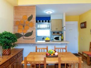 莱斯卡拉Apartment Residencial Gran Sol by Interhome的厨房配有一张桌子,上面放着一碗水果