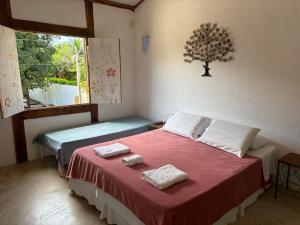 伊塔乌纳斯Vila Cizinho的一间卧室配有一张床,上面有两条毛巾