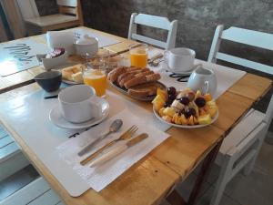 科洛尼亚-德尔萨克拉门托Ríos que nos unen的一张带早餐食品和橙汁的木桌