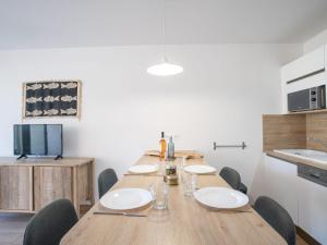 圣艾格夫Apartment Les Louvans-2 by Interhome的一间带木桌和椅子的用餐室