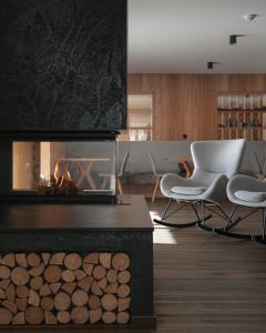 阿尔卑斯休斯山Brunelle Seiser Alm Lodge的客厅设有壁炉和2把椅子
