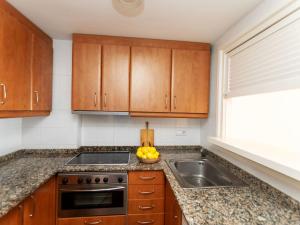 莱斯卡拉Apartment Port L'escala-1 by Interhome的厨房配有木制橱柜、水槽和一碗水果