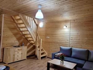 萨比诺瓦Domki Letniskowe Vitamin Sea的客厅设有蓝色的沙发和楼梯。