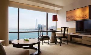 香港香港君悦酒店的客厅配有桌椅和大窗户